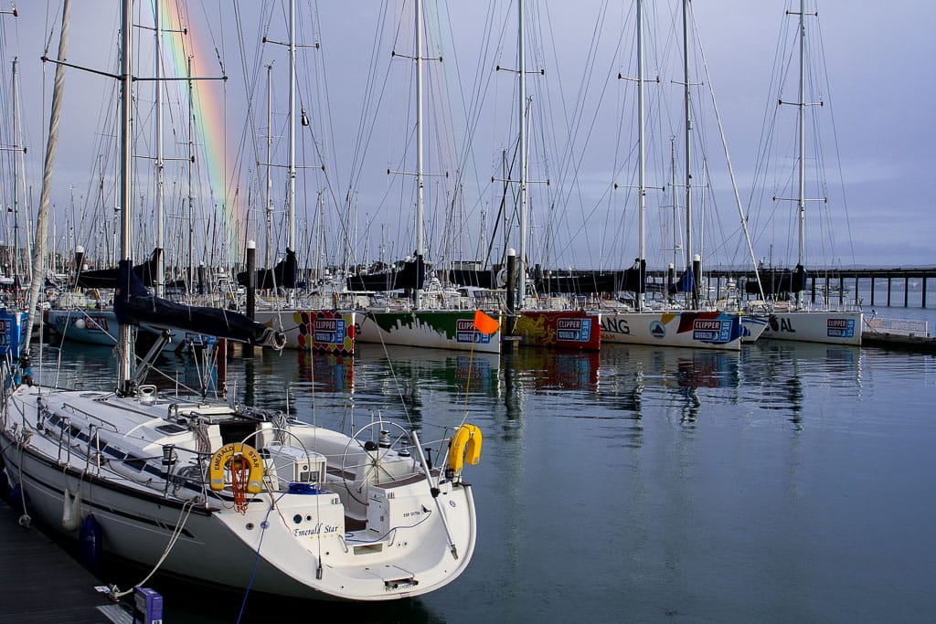winterise boat Solent — sailboats docked in a marina with a vivid rainbow in the sky