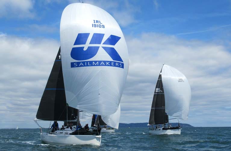 RYA Day Skipper vs Yachtmaster — sailboats racing across water under cloudy sky