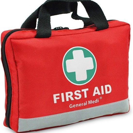 Red first aid kit with white cross on a green circle, labeled "FIRST AID General Medi." It has black handles and a zipper.