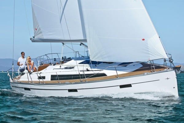 pass RYA practical exam first time — two people on a white sailboat navigating through clear waters