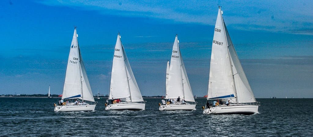 RYA Day Skipper vs Yachtmaster — four Bavaria sailing yachts cruising together under white sails