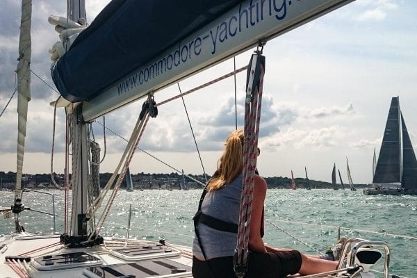 pass RYA practical exam first time — person relaxing on a yacht in sunny weather viewing other sailboats