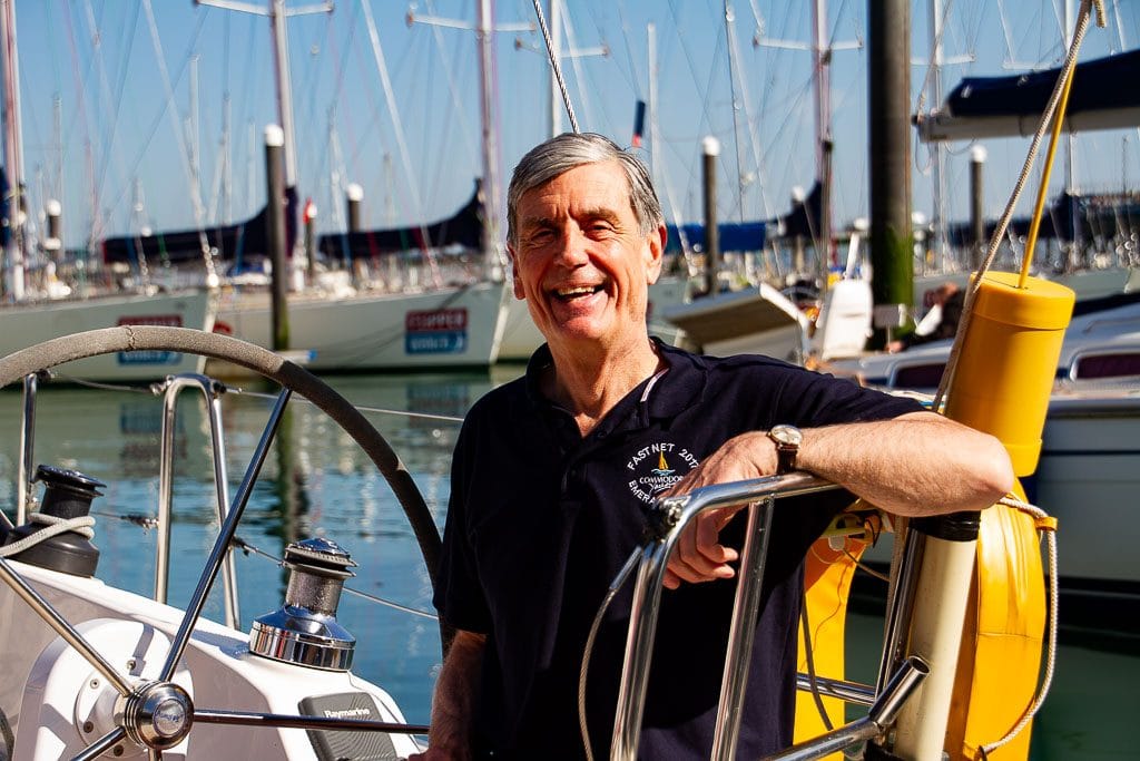 pass RYA practical exam first time — person smiling on a sailboat in a marina with other boats