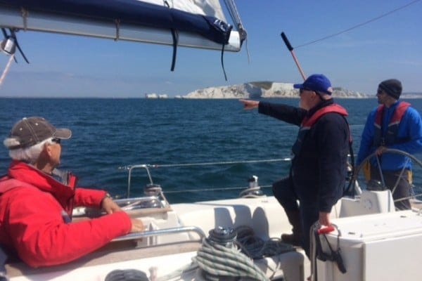 pass RYA practical exam first time — three people sailing near The Needles Isle of Wight