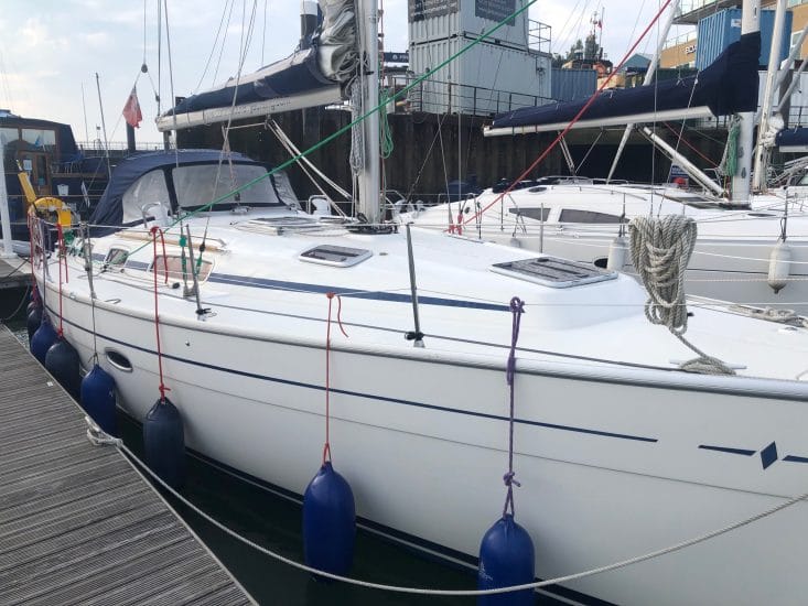 Christmas gift guide for sailors — white sailboat docked at a marina with fenders and ropes
