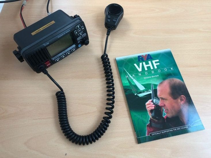 engine failure Solent — VHF radio with microphone on table next to RYA handbook
