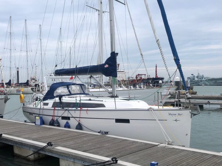online vs classroom RYA theory — marina with multiple sailboats including a white vessel