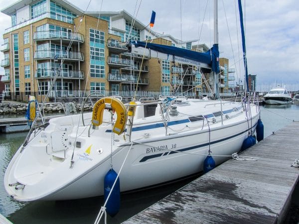 winterise boat Solent — a sailboat docked in a marina beside modern apartment buildings