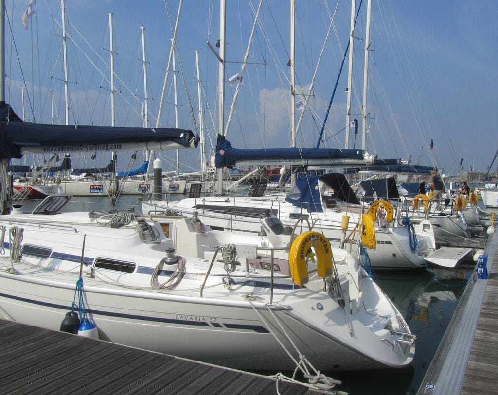 winterise boat Solent — docked sailboats with tall masts and yellow life rings