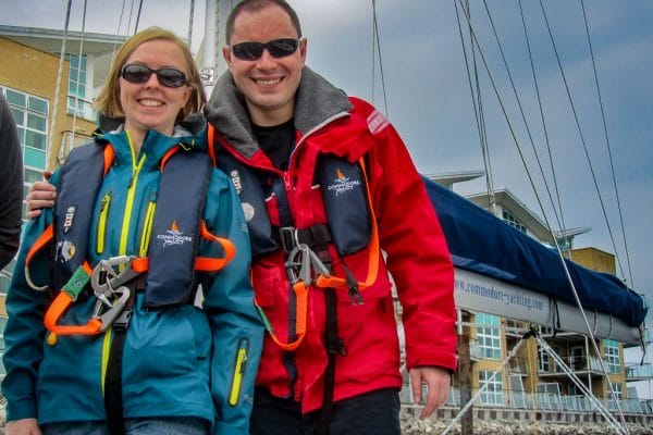 learning to sail at 40 — two people in sailing gear and sunglasses smiling onboard