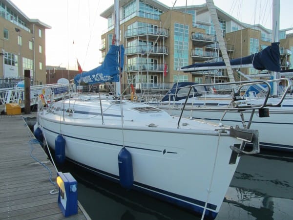 winterise boat Solent — white sailboat docked at marina surrounded by modern apartments