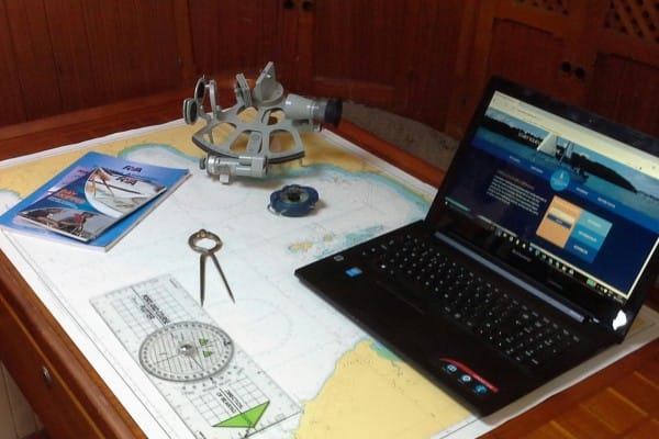 engine failure Solent — nautical chart table with sextant laptop marine plotter and dividers