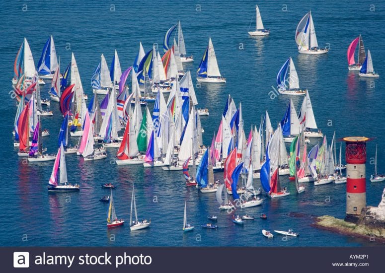 RYA Day Skipper vs Yachtmaster — colorful regatta of sailboats rounding a lighthouse